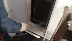 Applying duct sealer to the interior liner in a fan coil unit.